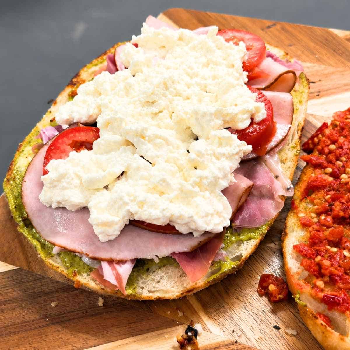 Sandwich topped with burrata.