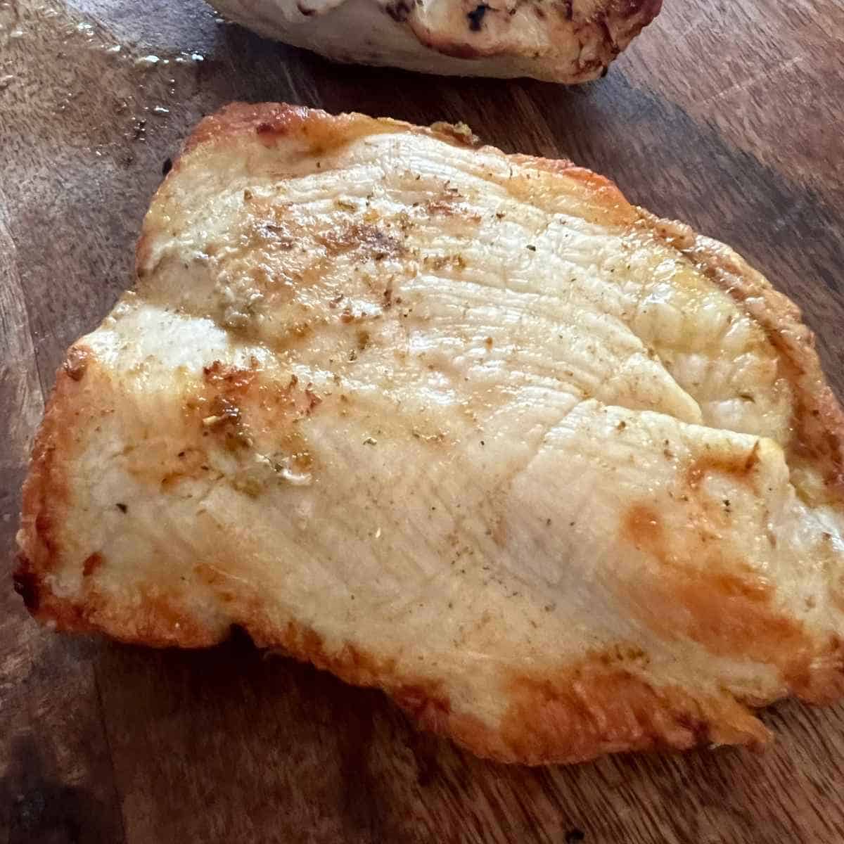 Air fryer frozen chicken breast that. has been seasoned and cooked.