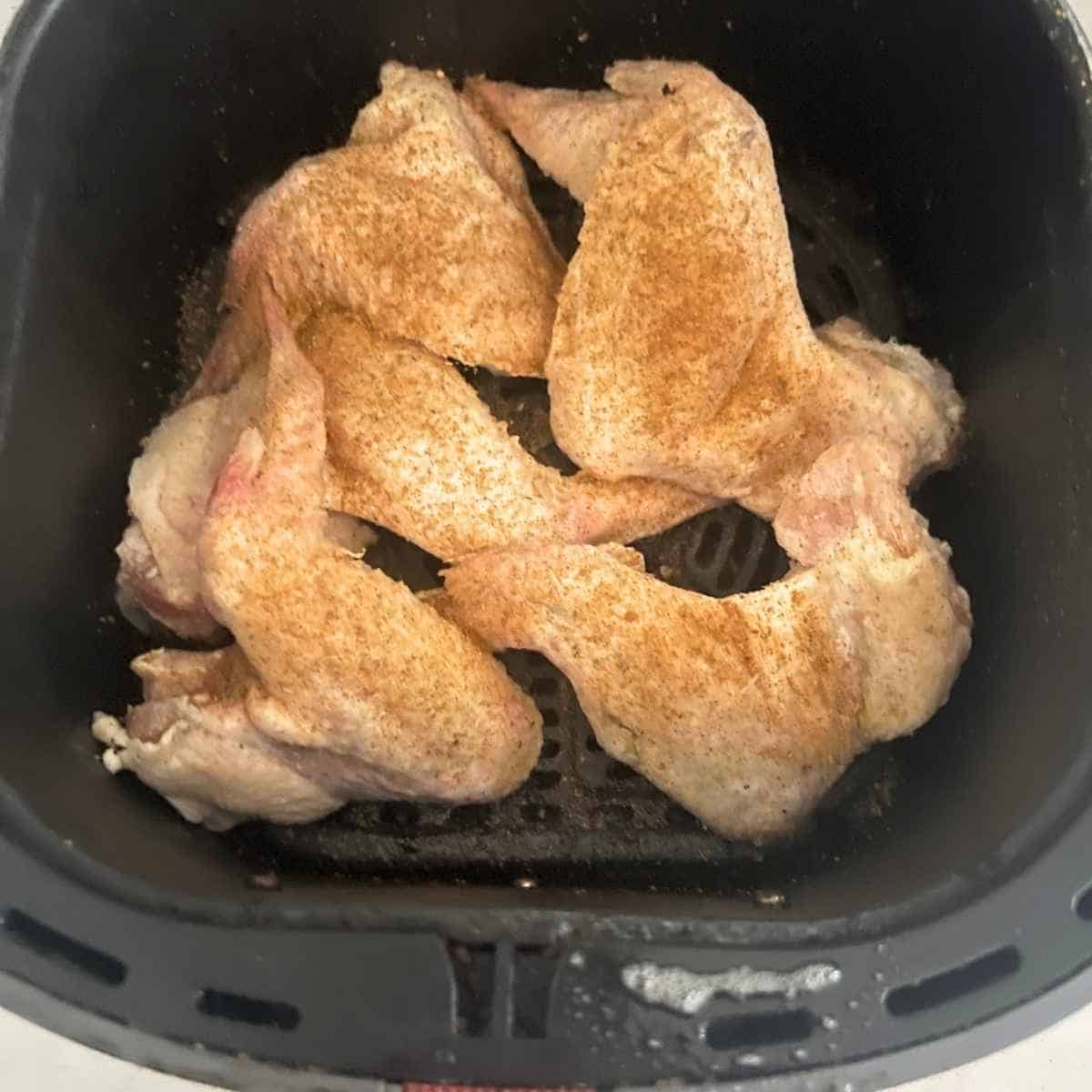 Frozen seasoned chicken wings in air fryer. 