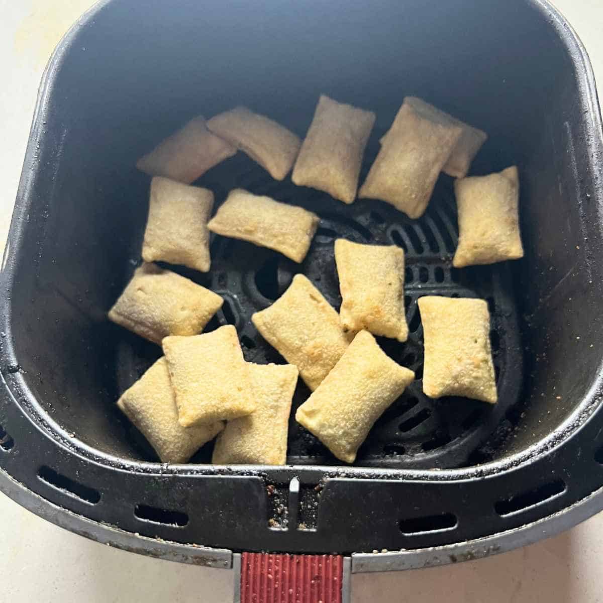 Pizza rolls in air fryer basket. 
