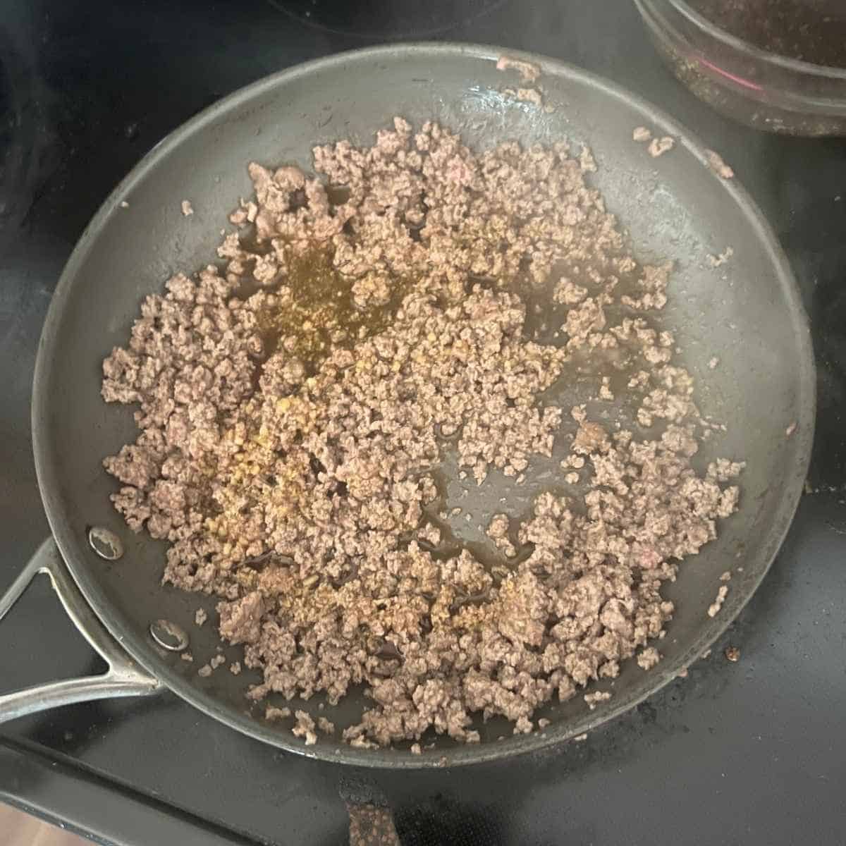 Ground beef frying in a pan.