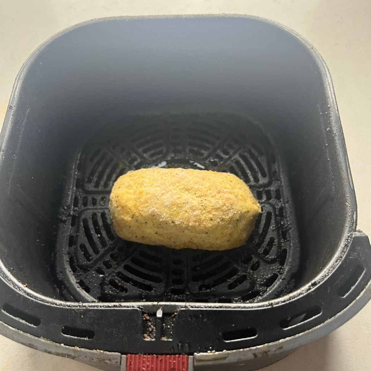 Frozen chicken cordon blue in air fryer basket.