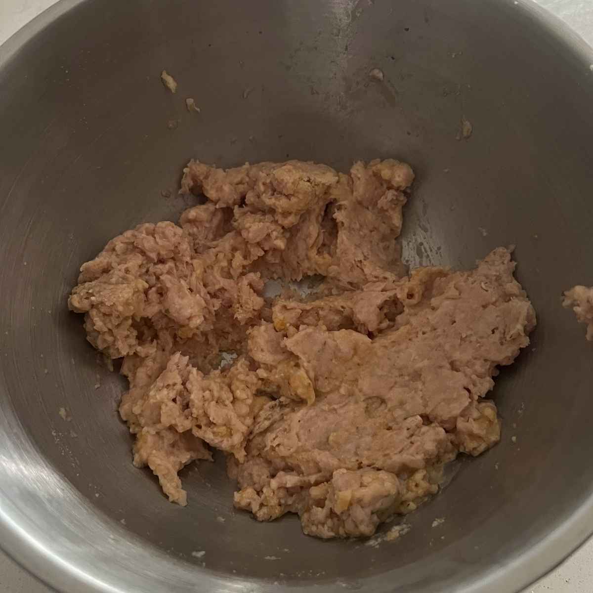 Combined chicken meatball mixture in a bowl.