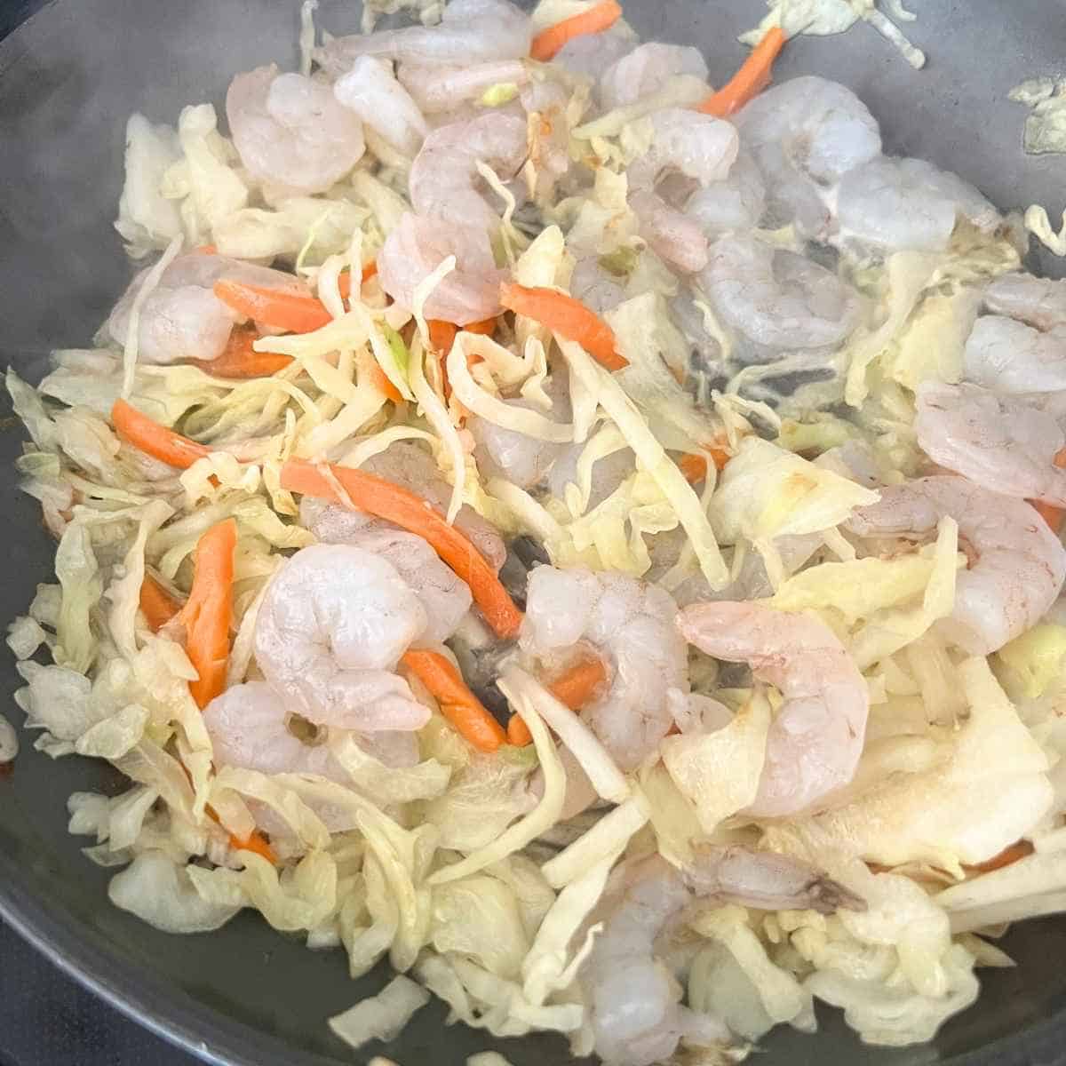 Shrimp with cabbage in a skillet.