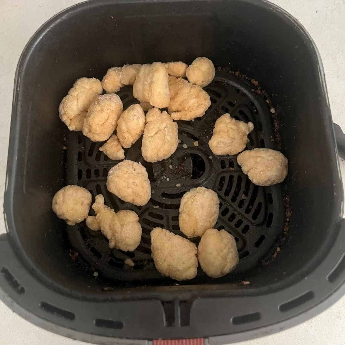 Fried chicken in air fryer basket.
